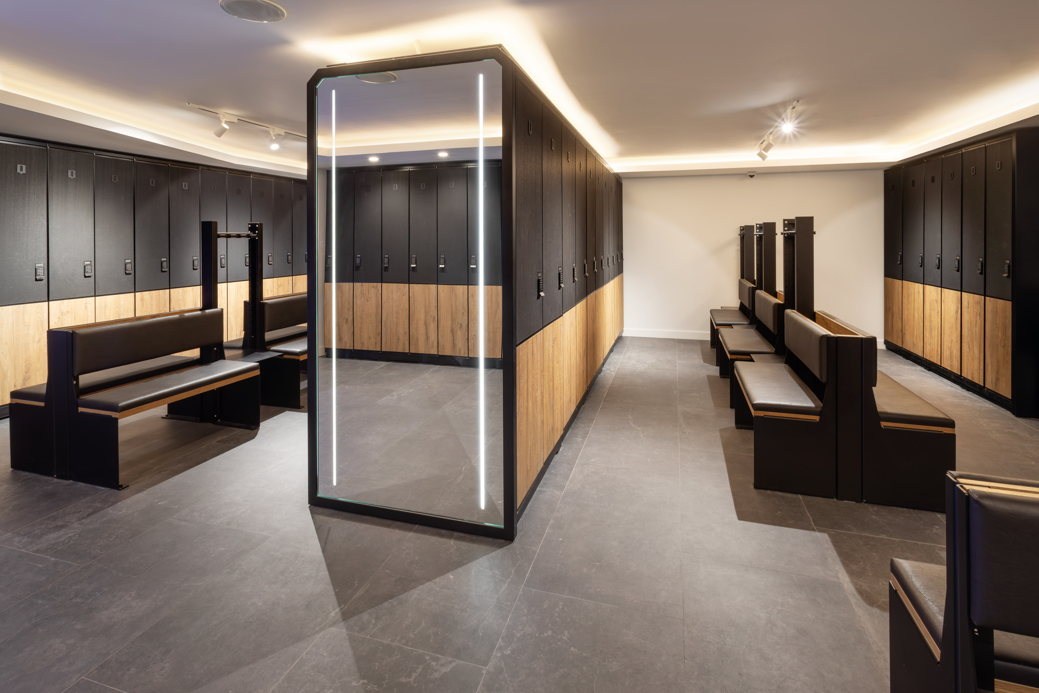 a locker room with a glass wall and benches