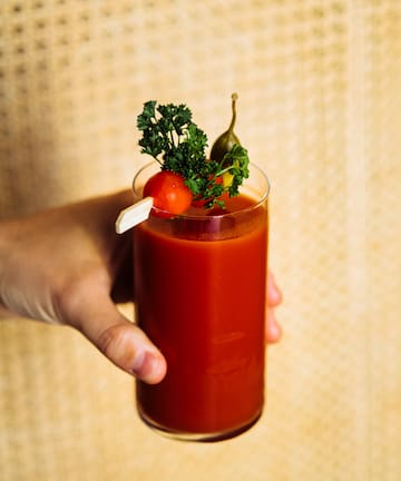 a hand holding a glass of bloody mary