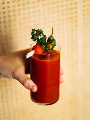 a hand holding a glass of bloody mary