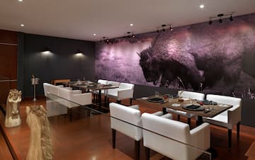 a room with white chairs and tables and a large picture of a buffalo