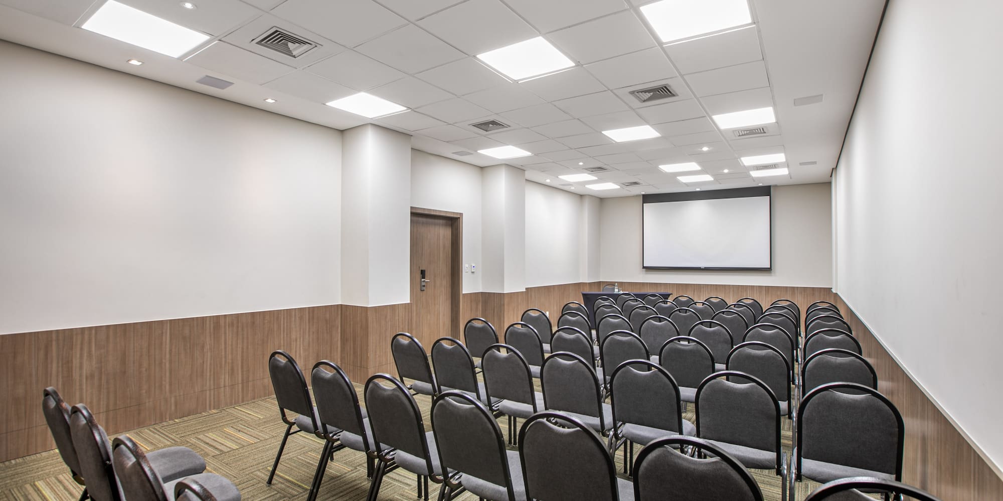 a room with chairs and a projector screen