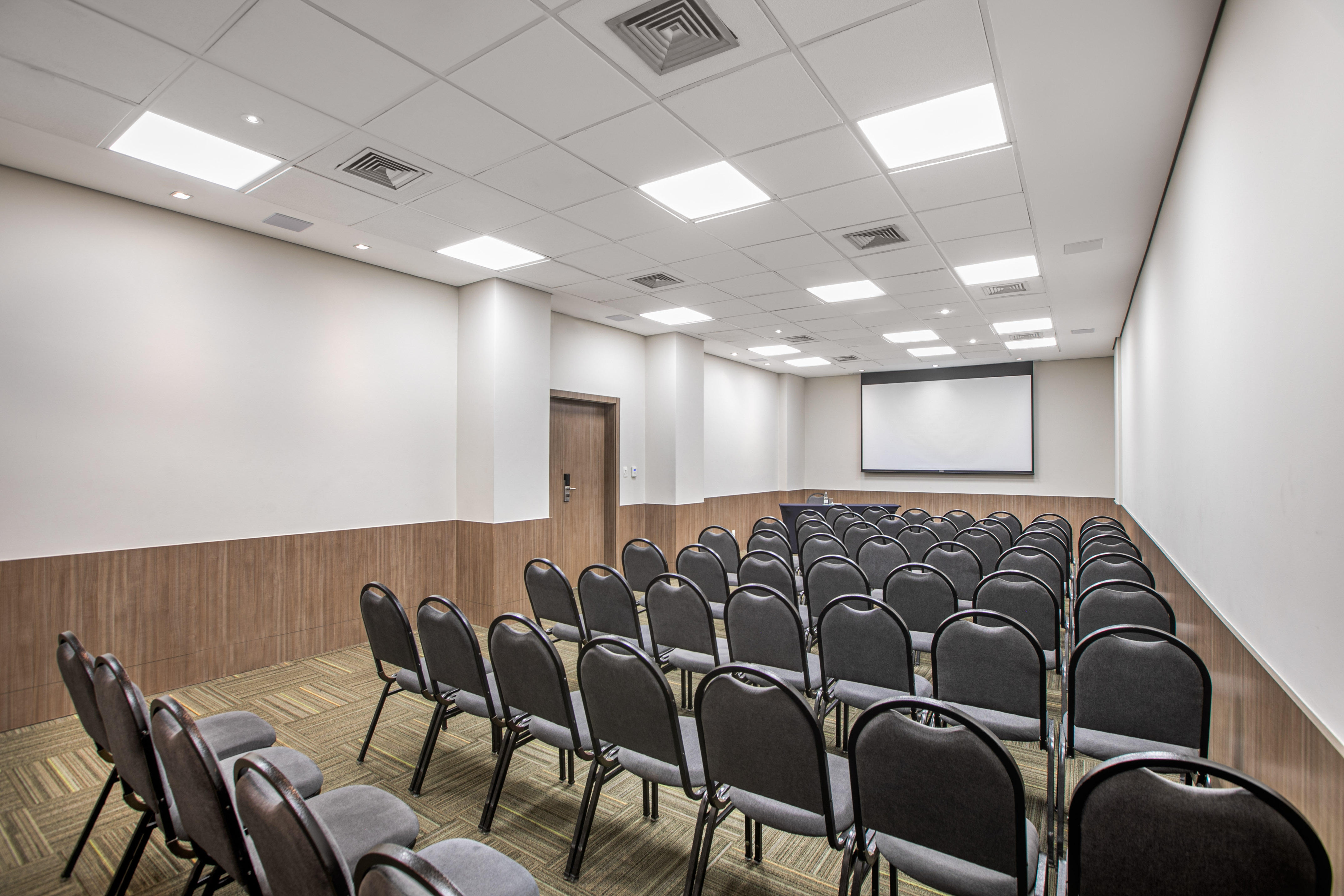 a room with chairs and a projector screen