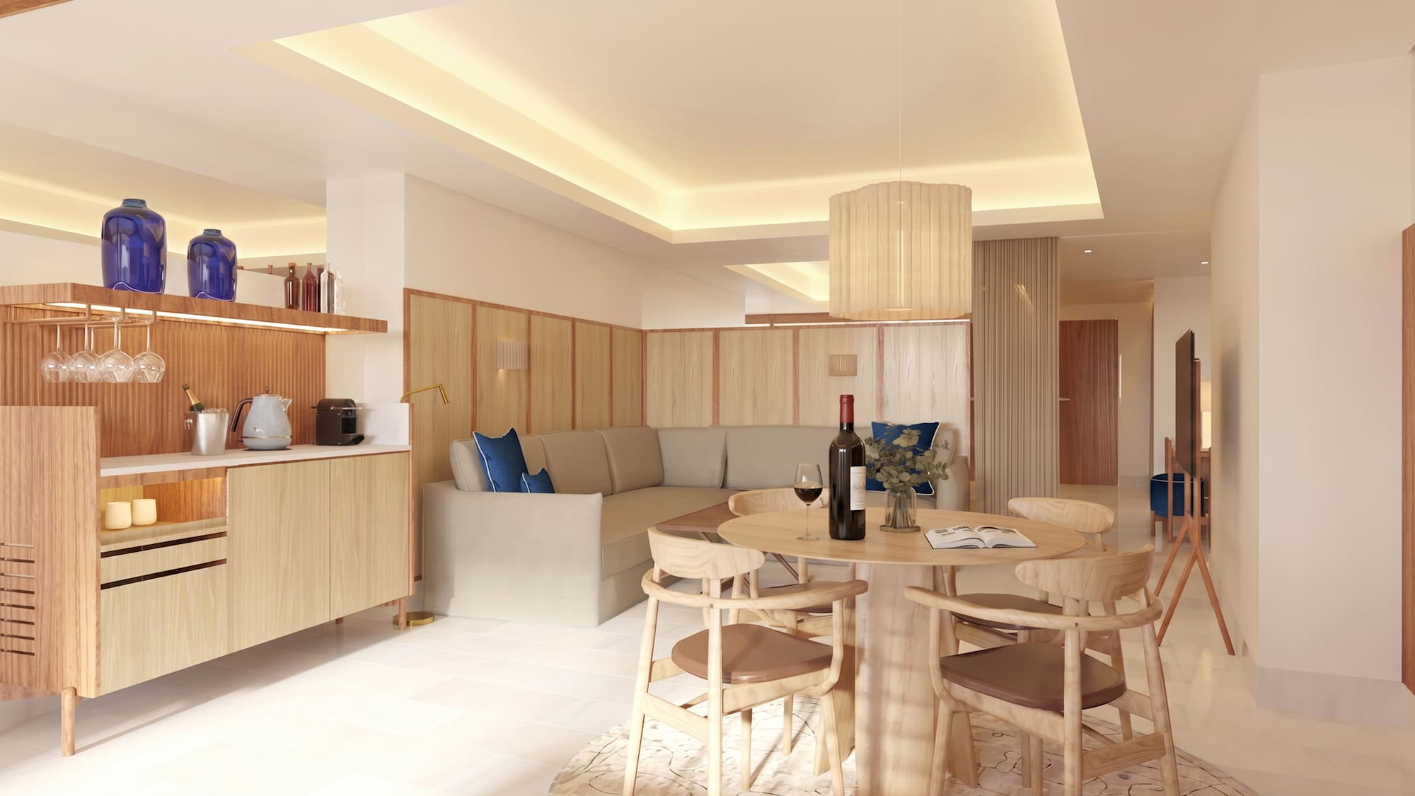 Modern hotel suite living room with dining table, sofa, and kitchenette.