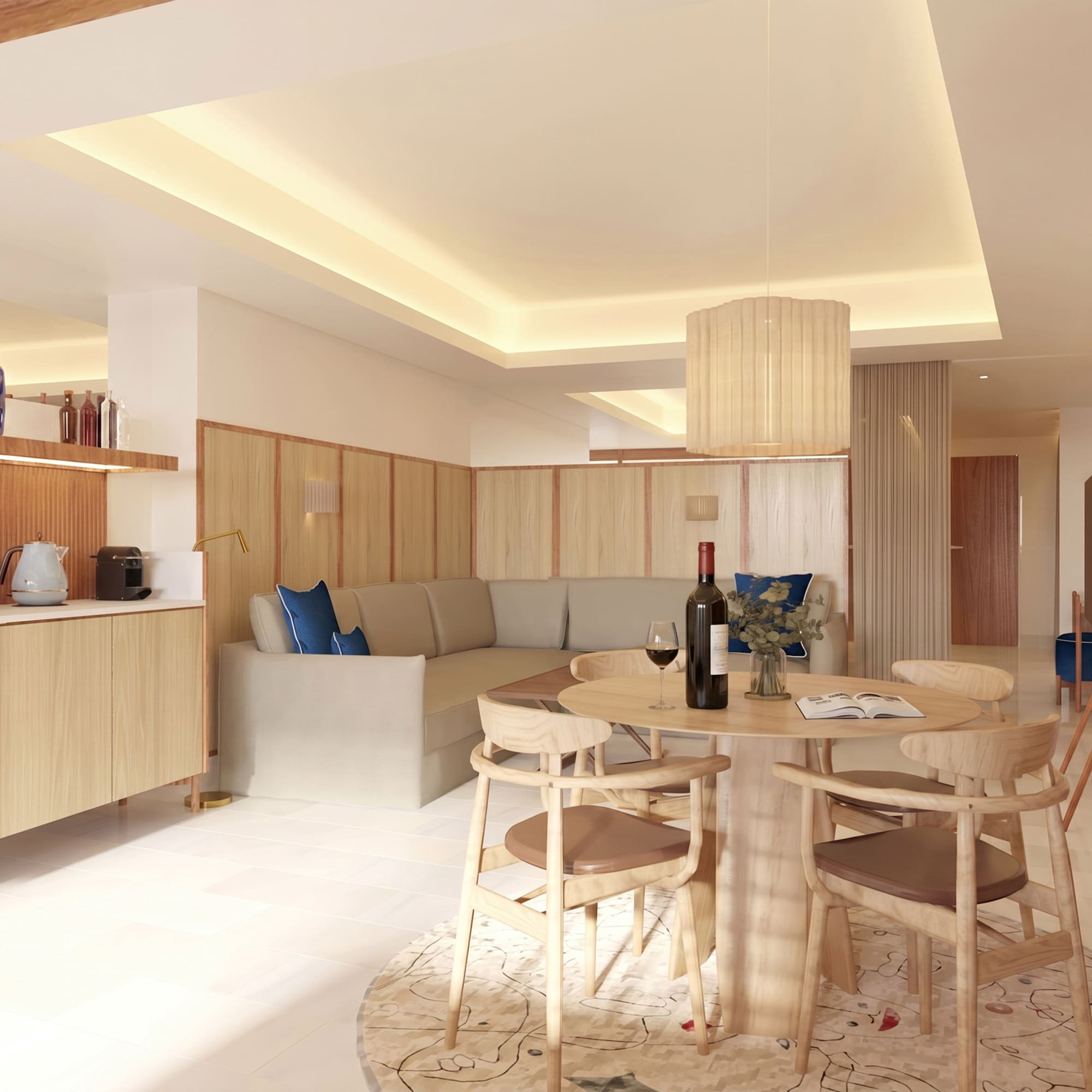 Modern hotel suite living room with dining table, sofa, and kitchenette.