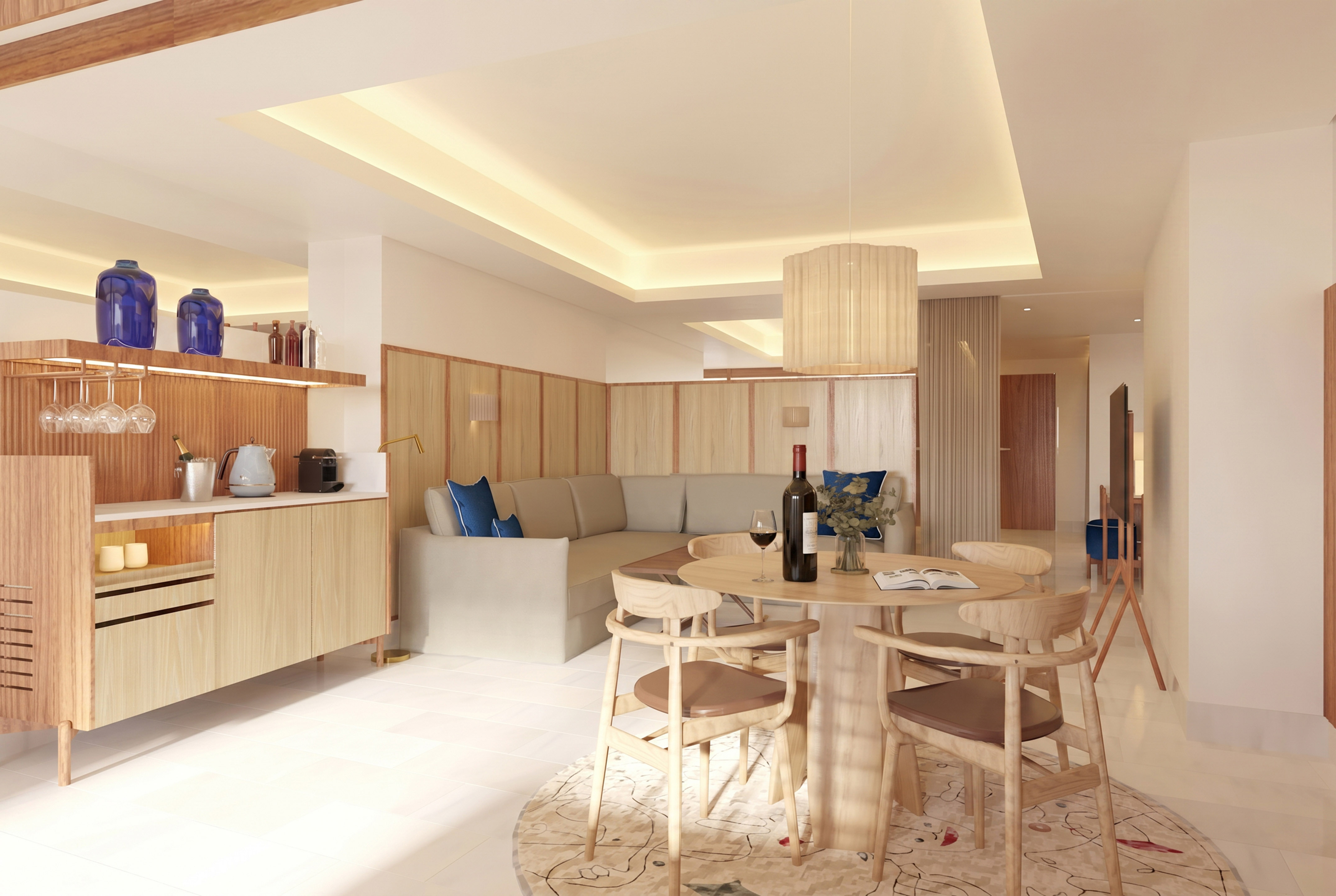 Modern hotel suite living room with dining table, sofa, and kitchenette.
