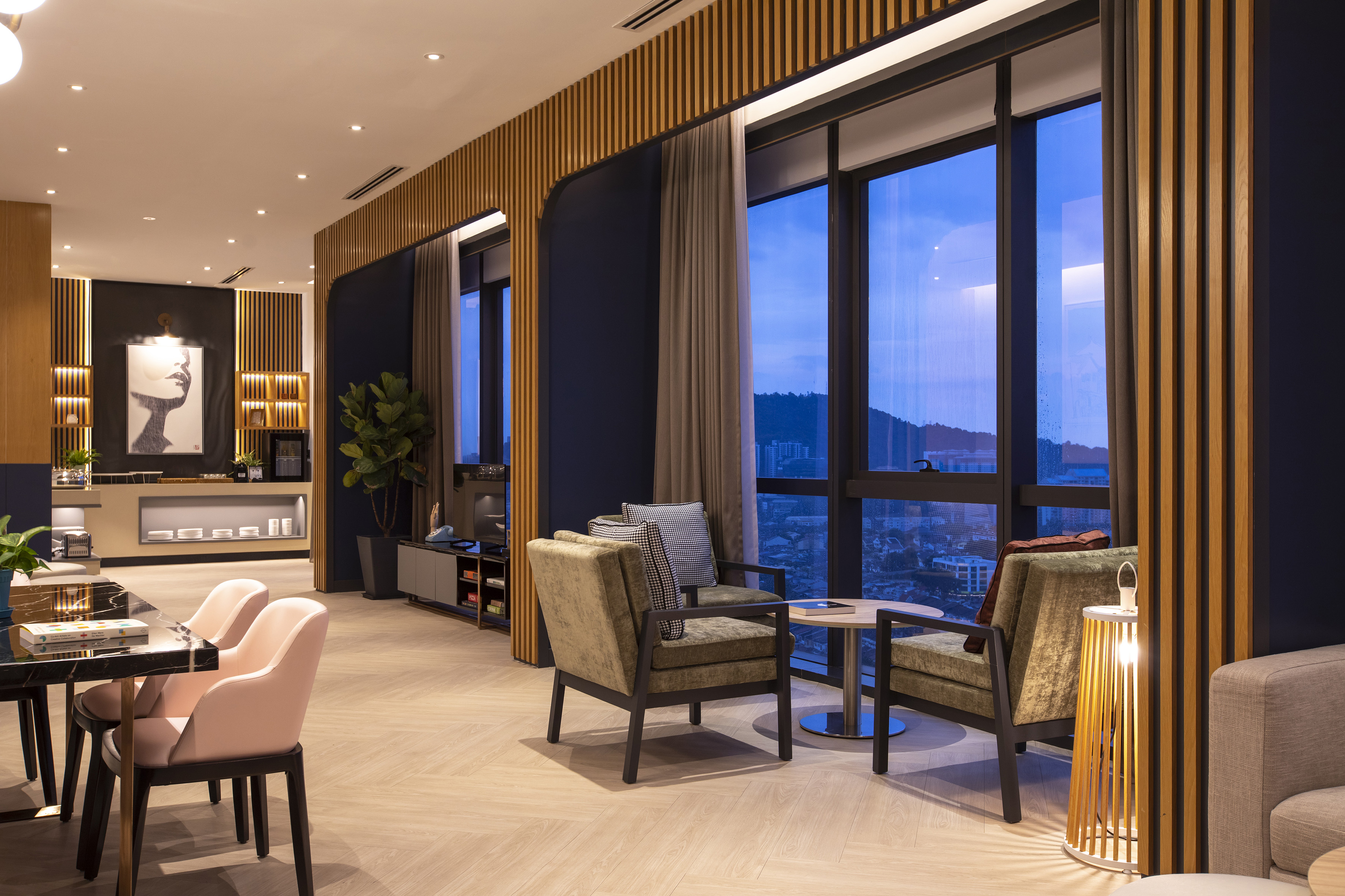 Modern lounge with city view, large windows, wood accents, and stylish furniture.