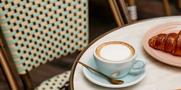 a coffee and croissant on a table