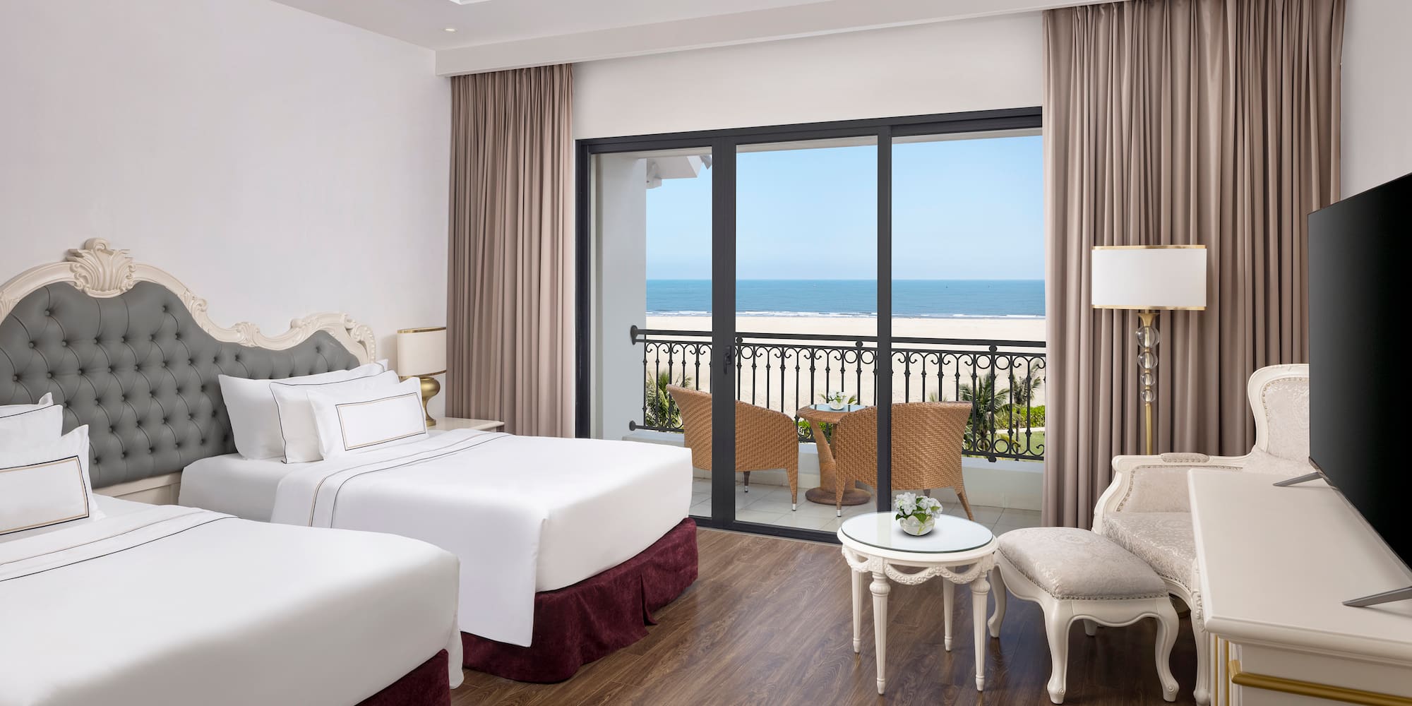 a room with two beds and a table and chairs