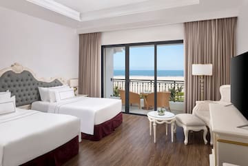 a room with two beds and a table and chairs