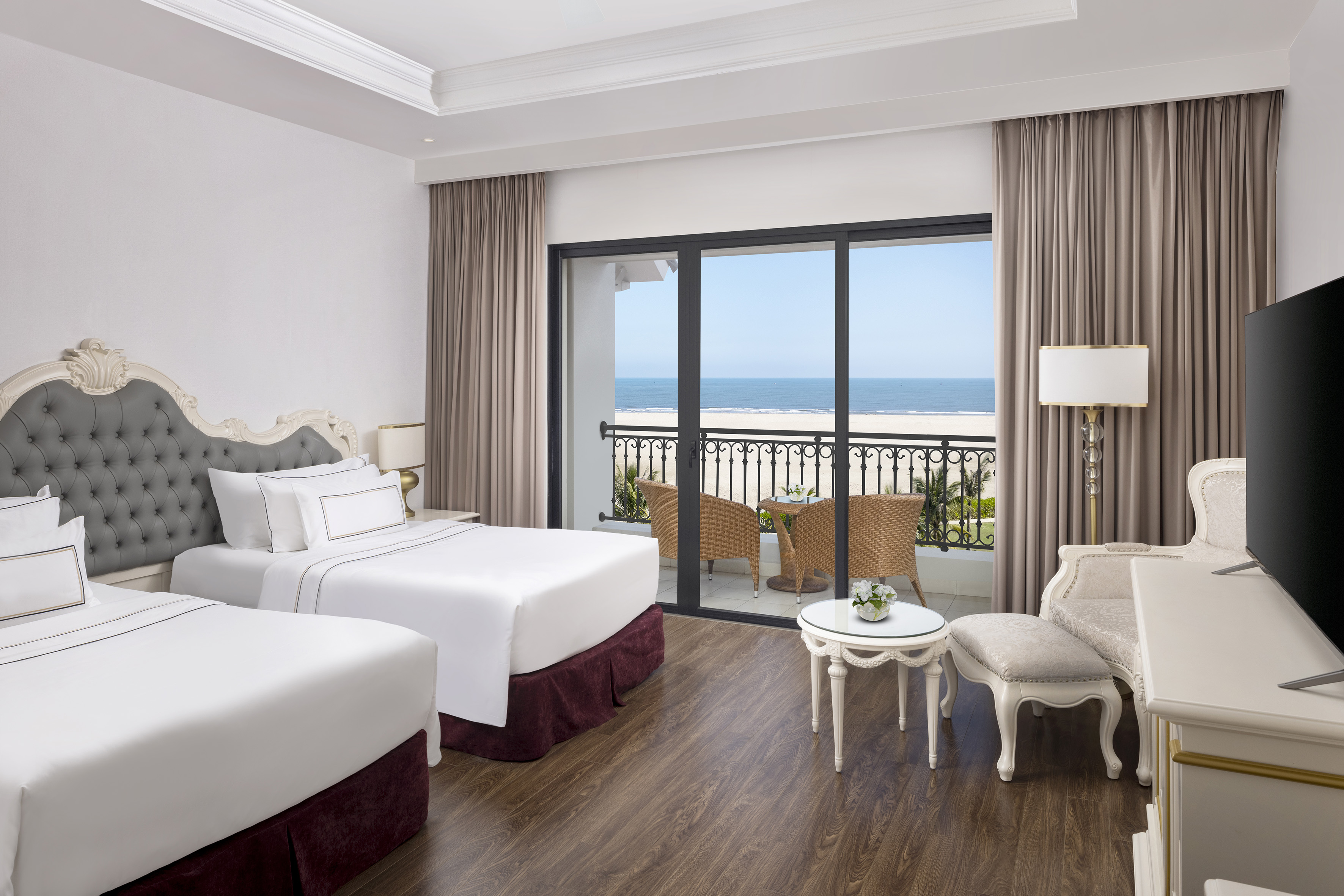 a room with two beds and a table and chairs