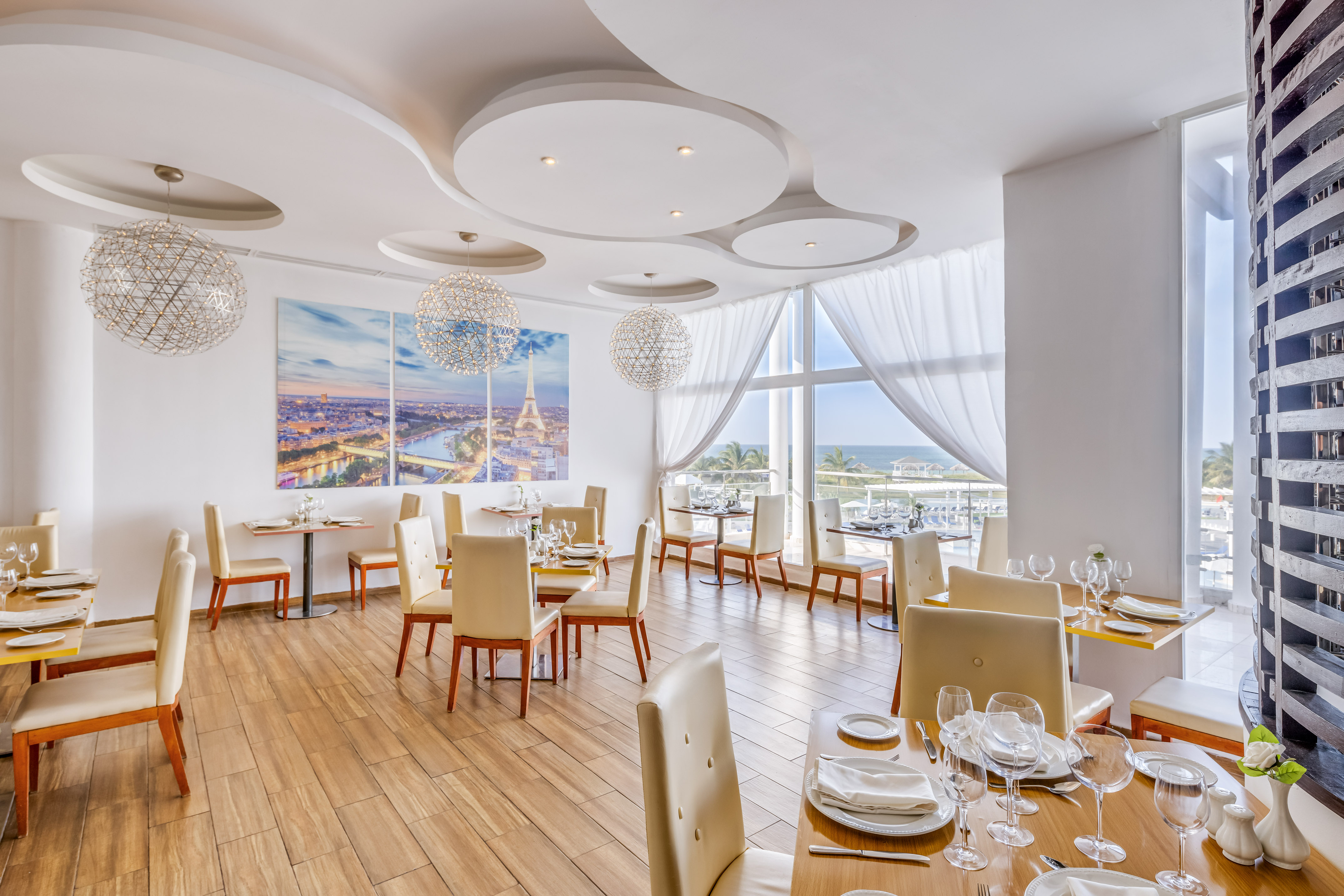 a room with tables and chairs and a large window