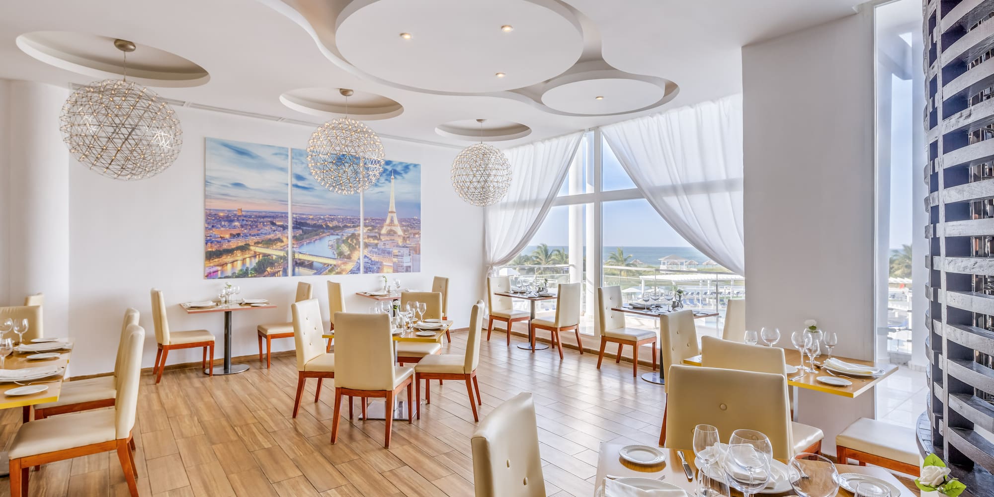 a room with tables and chairs and a large window