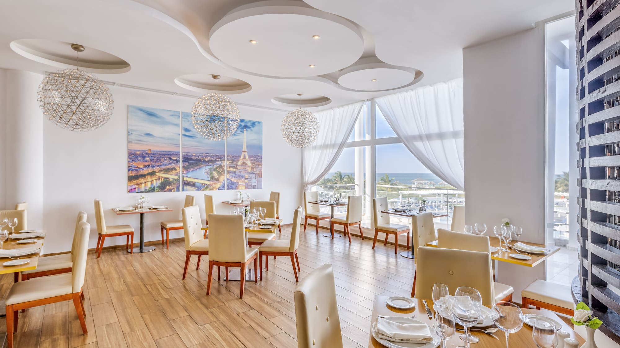 a room with tables and chairs and a large window