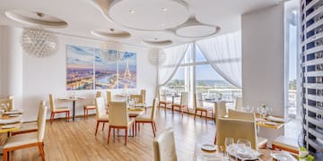 a room with tables and chairs and a large window