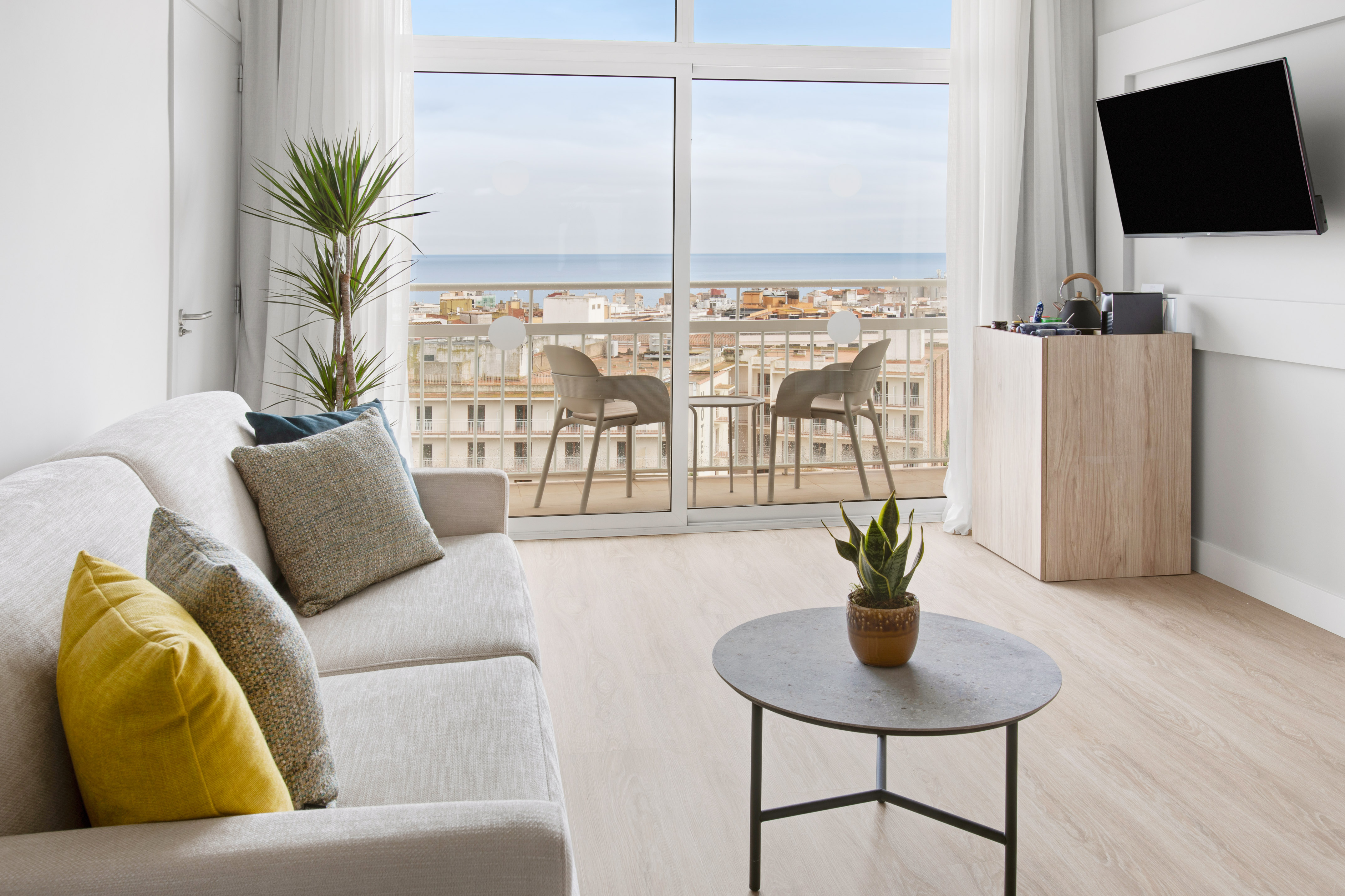 Modern living room with sea view balcony and sofa.