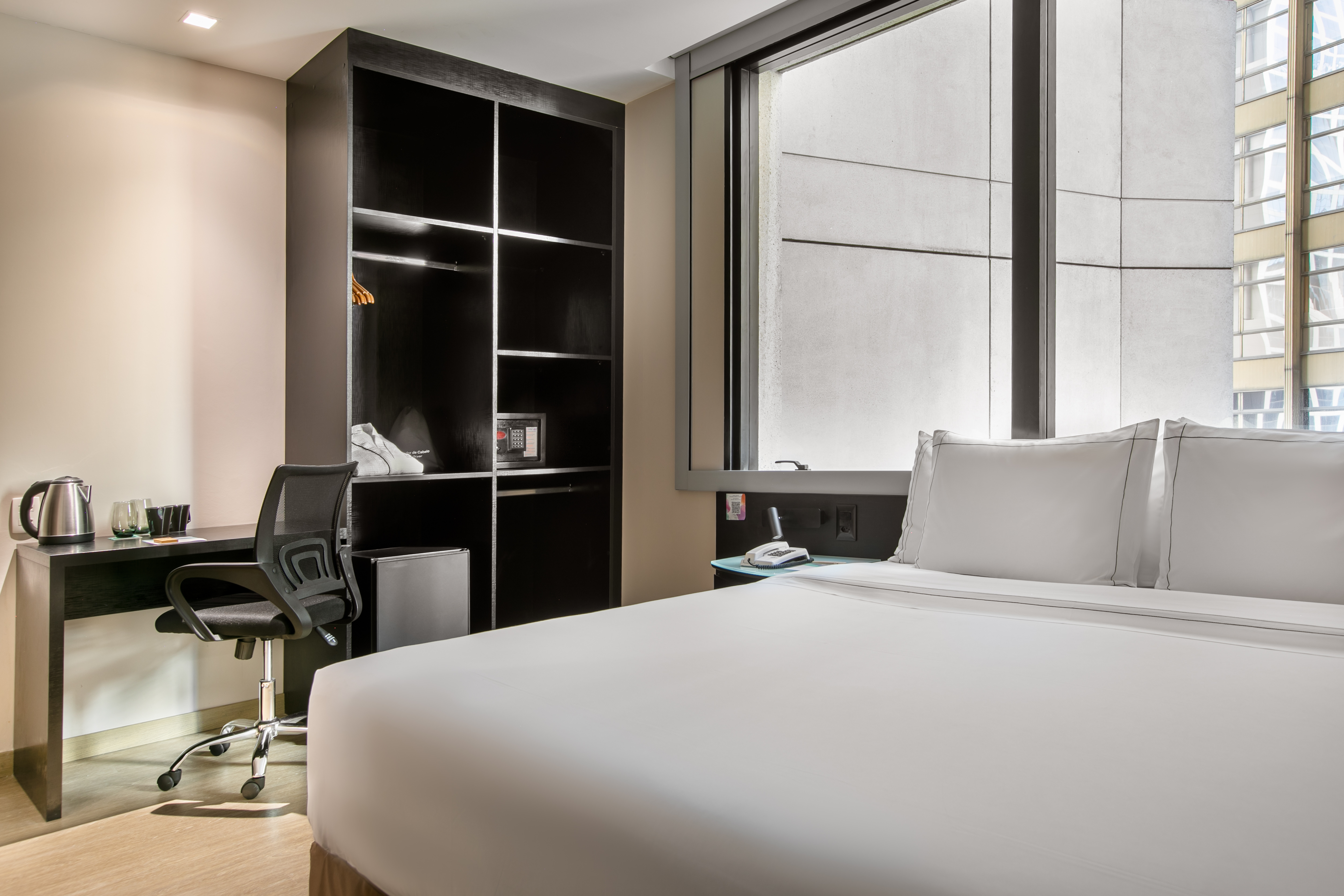 a room with a bed and a desk and a bookcase