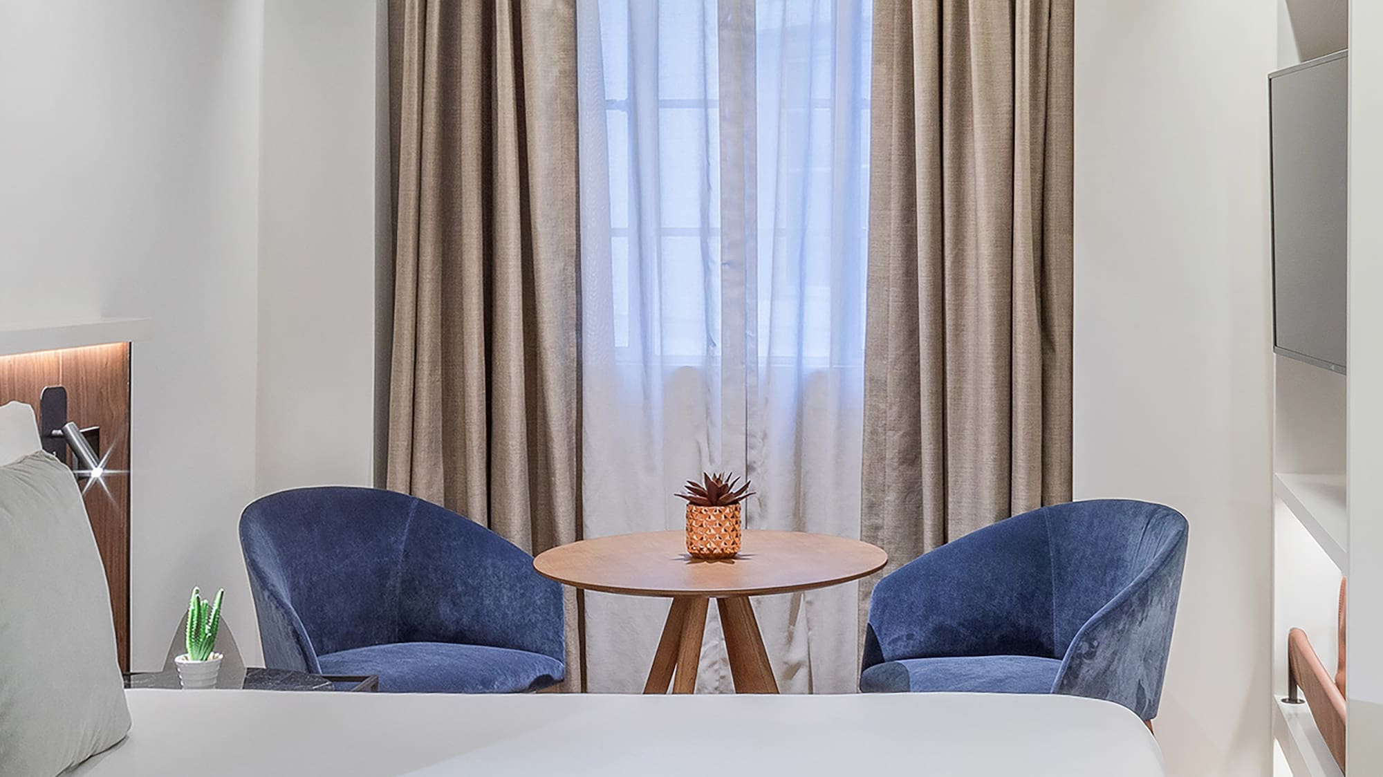 a room with a bed and chairs