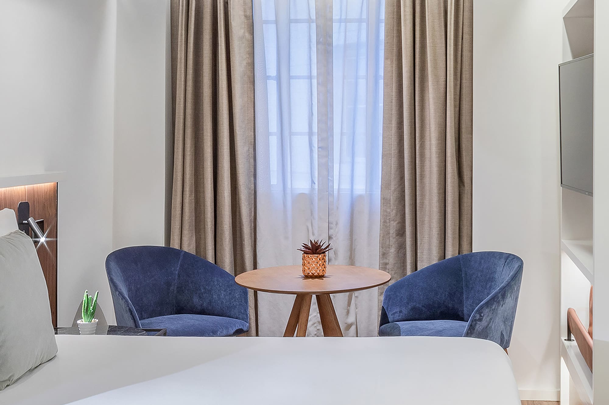 a room with a bed and chairs