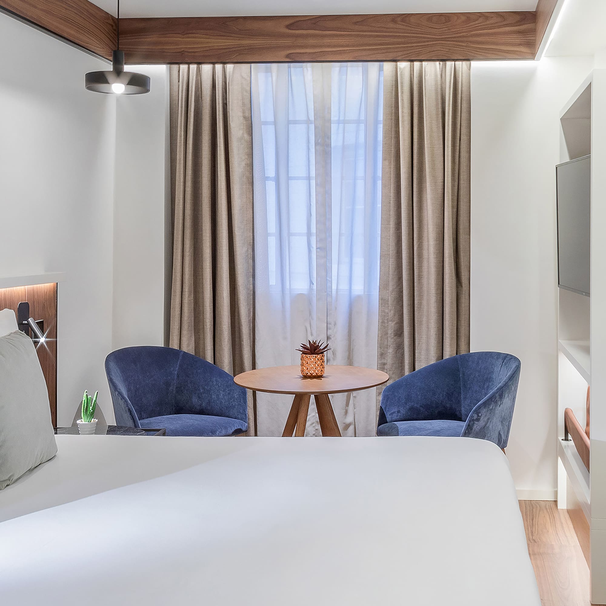 a room with a bed and chairs