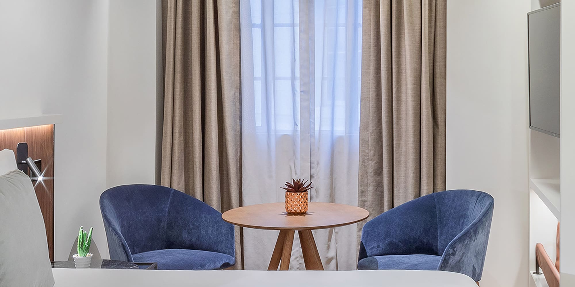 a room with a bed and chairs