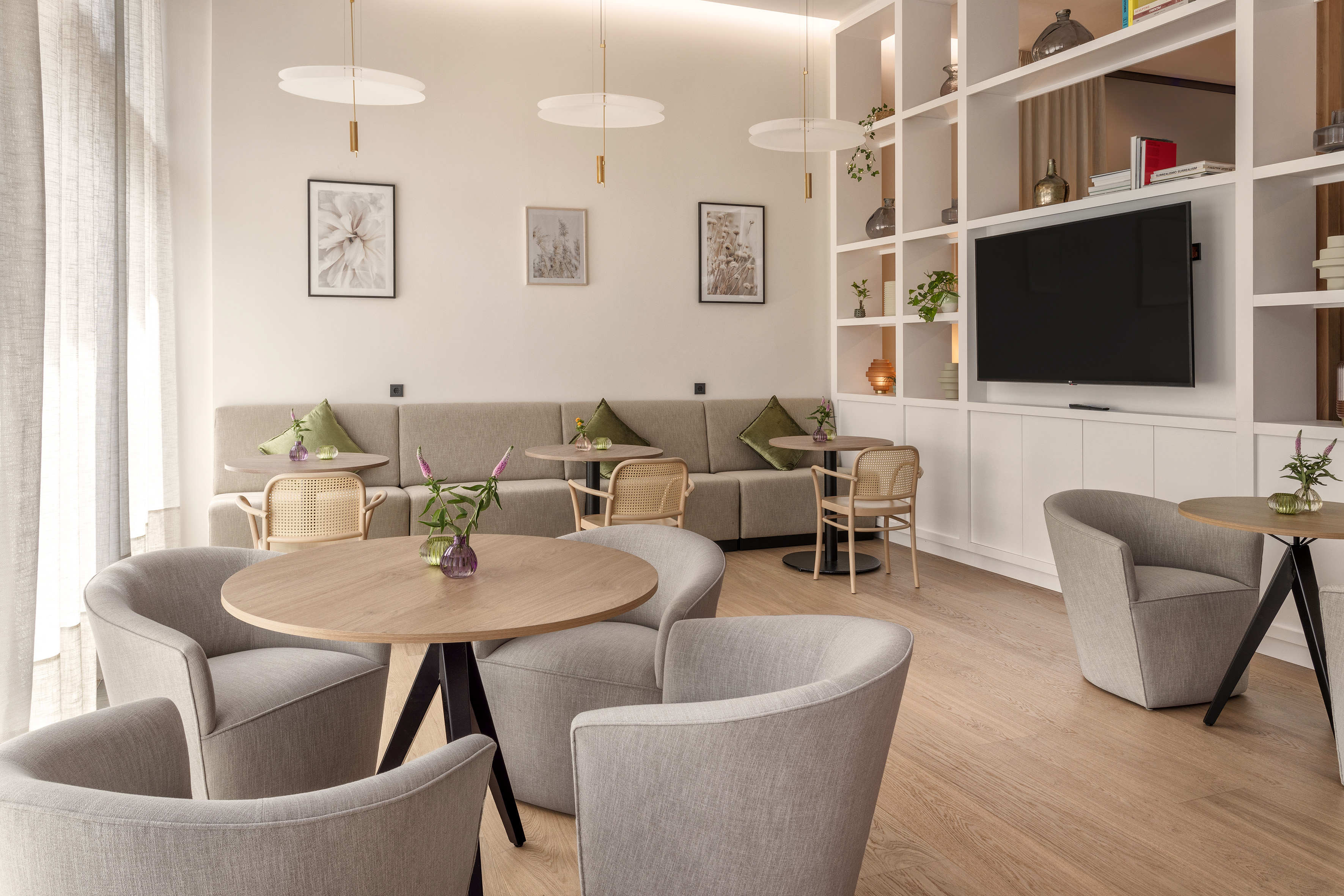 Modern hotel lobby lounge with comfortable seating, round tables, and contemporary decor.