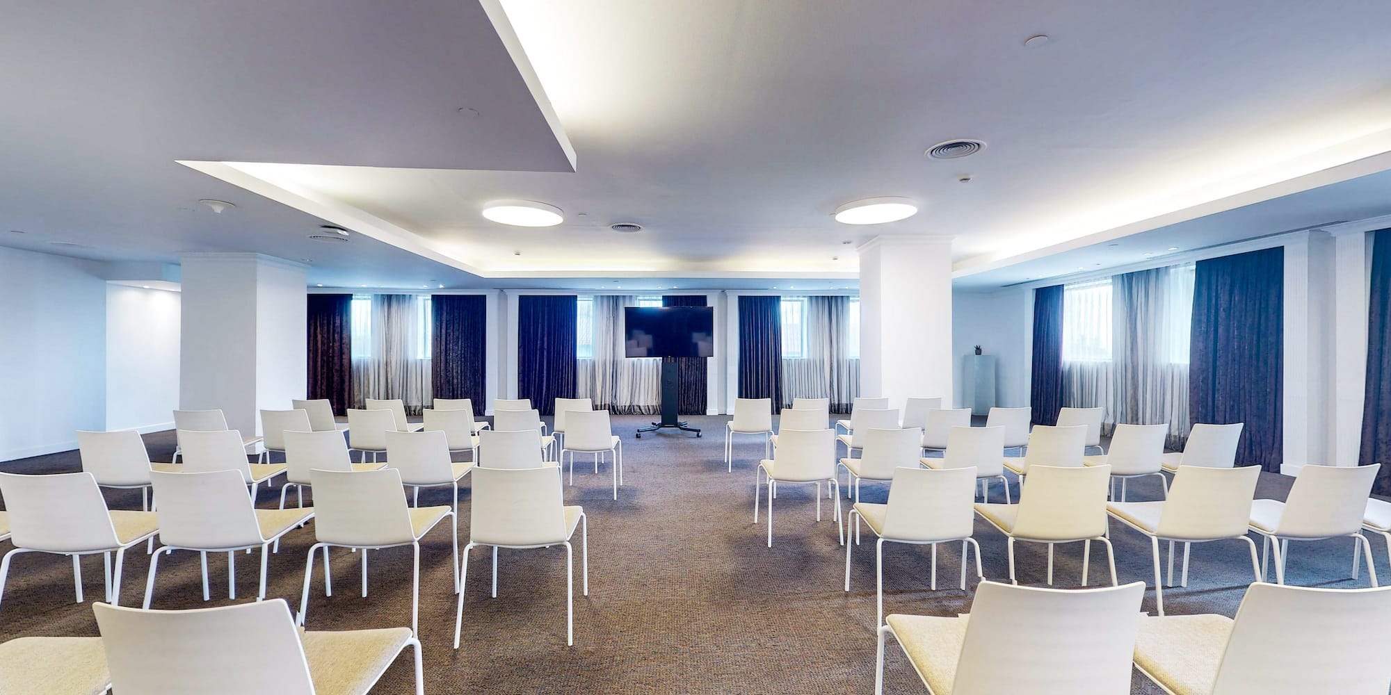 a room with white chairs and a podium