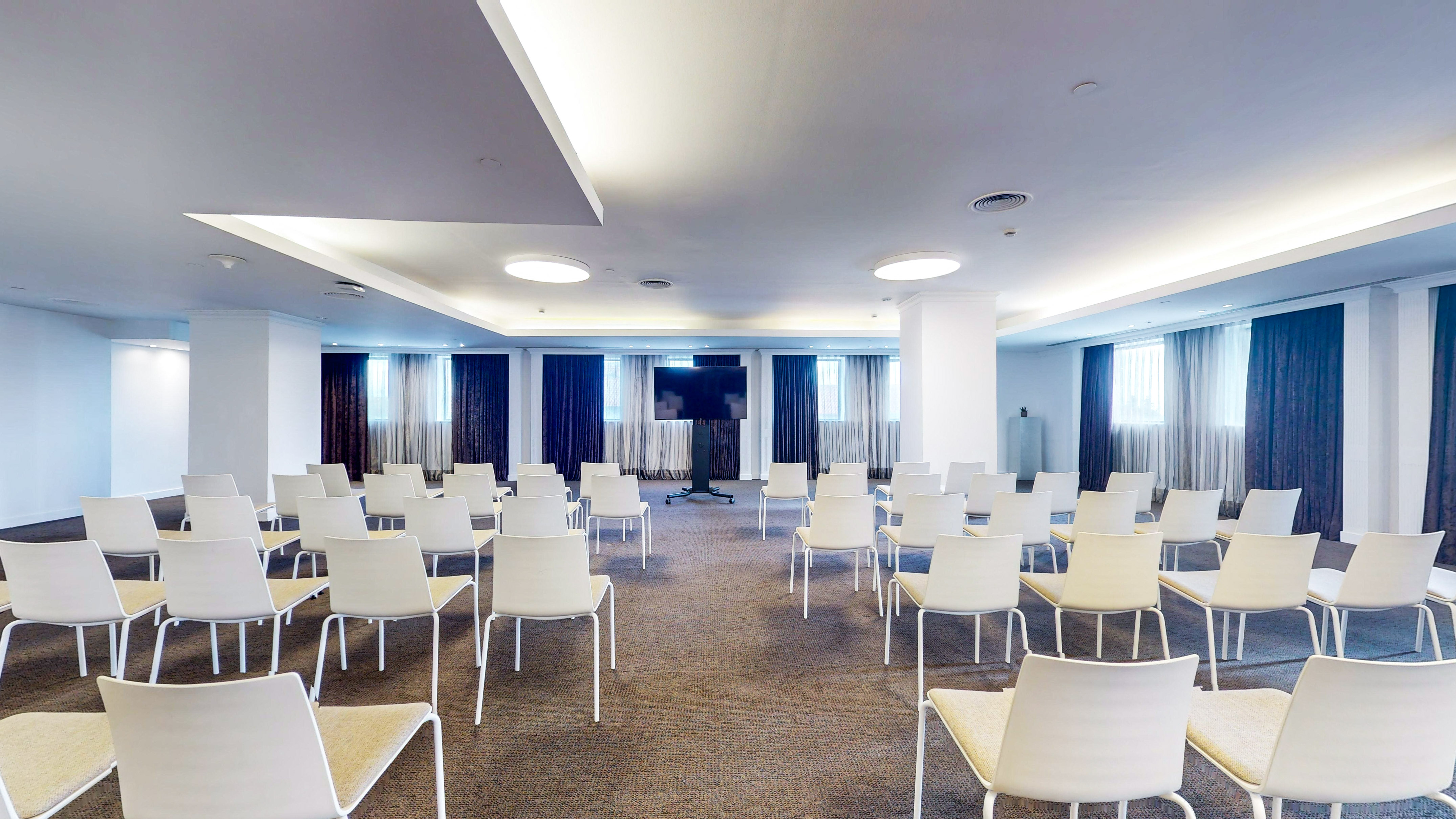 Modern conference room setup with empty chairs and a large presentation screen.