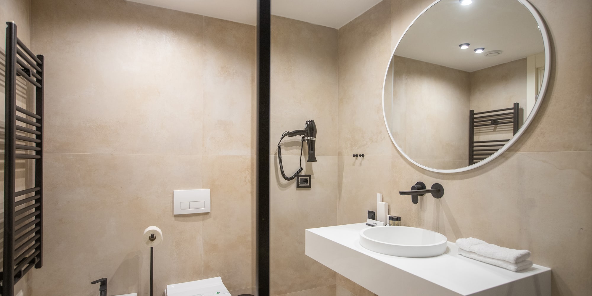 a bathroom with a round mirror and sink