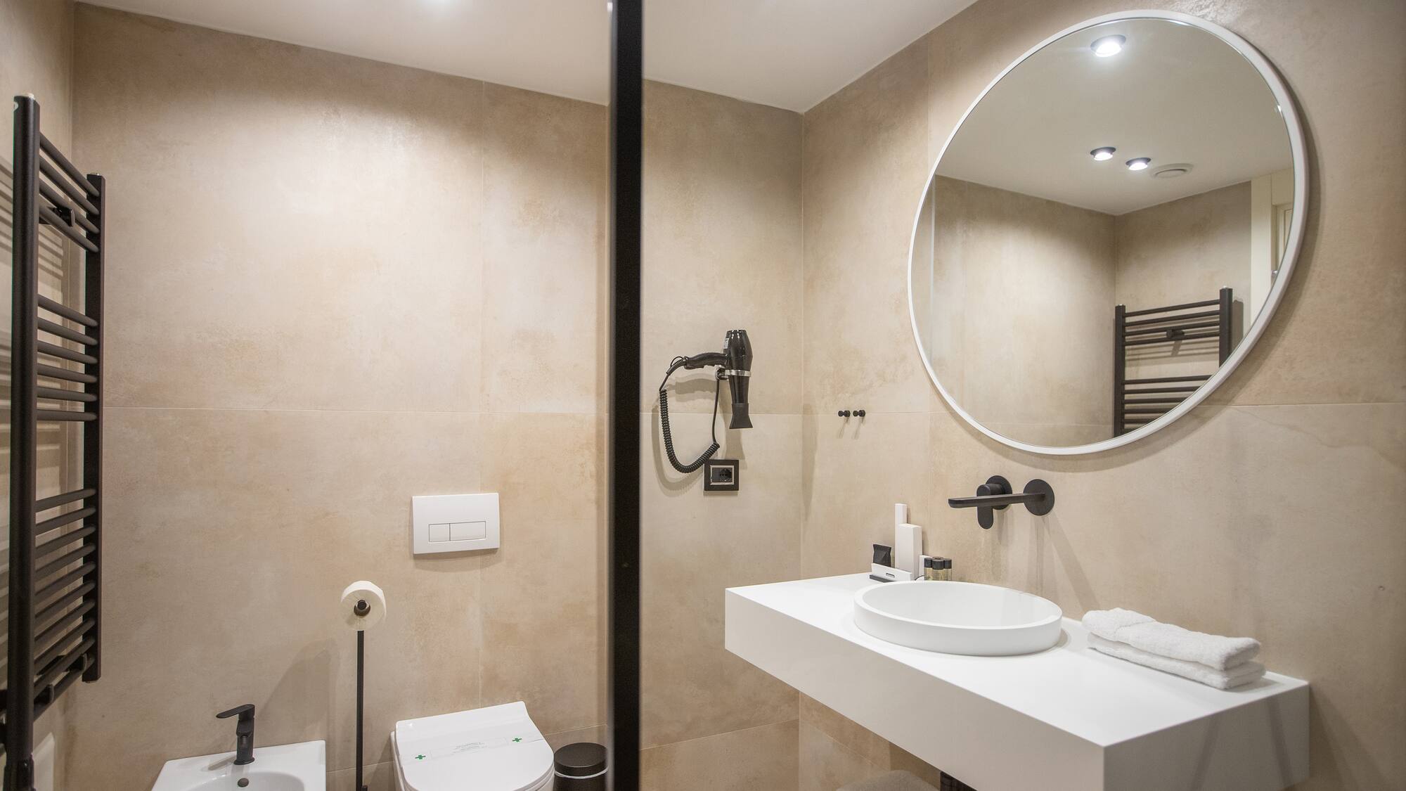 a bathroom with a round mirror and sink