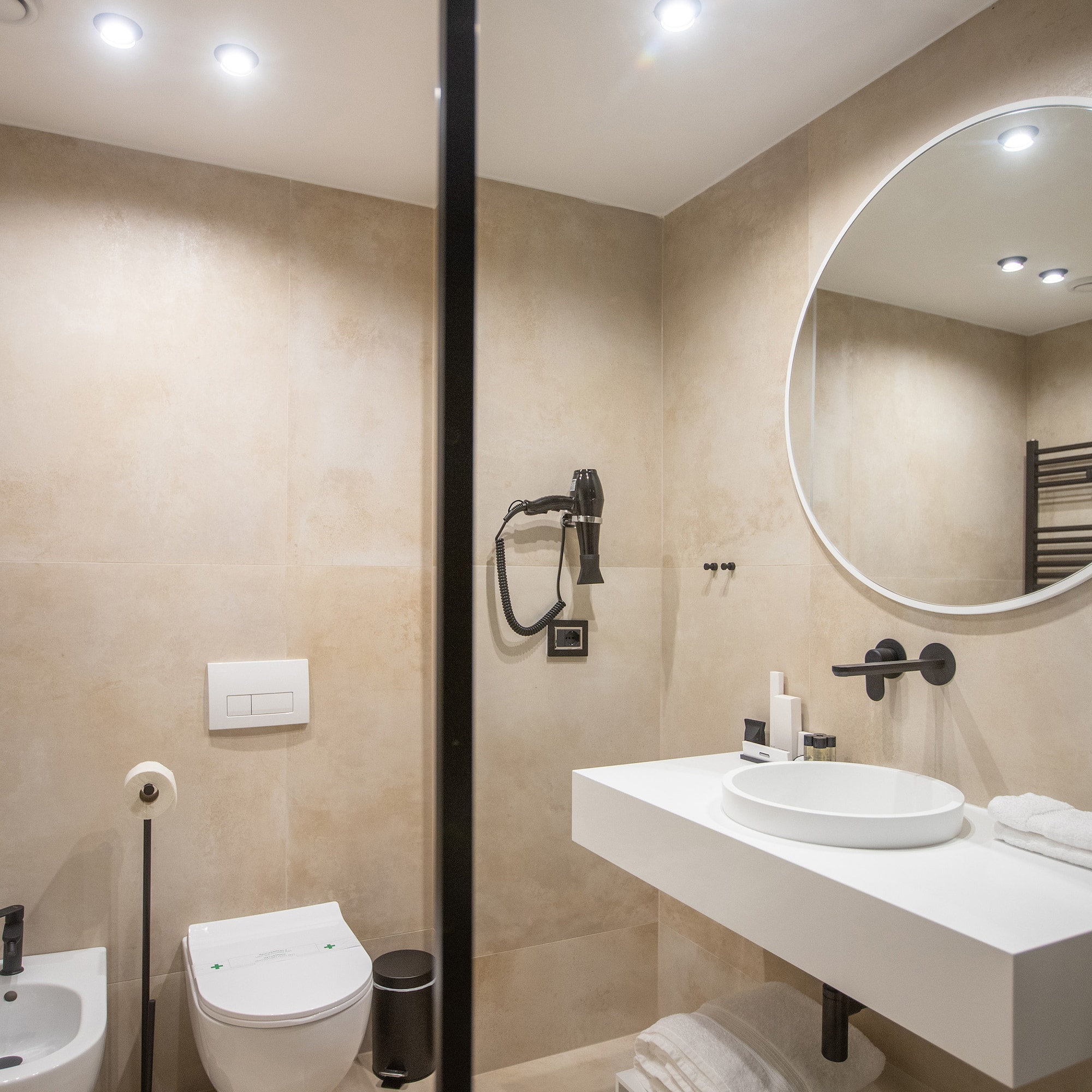 a bathroom with a round mirror and sink