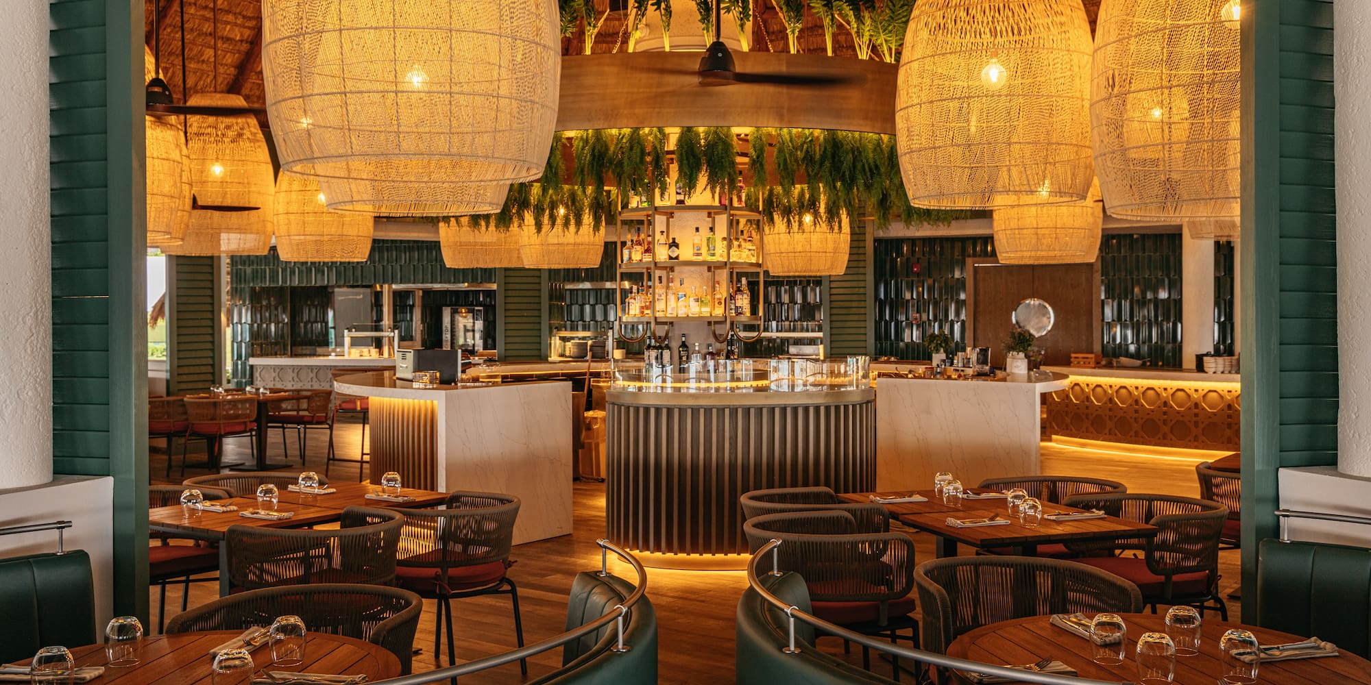 Tropical resort restaurant bar with large woven pendant lights and central circular bar.