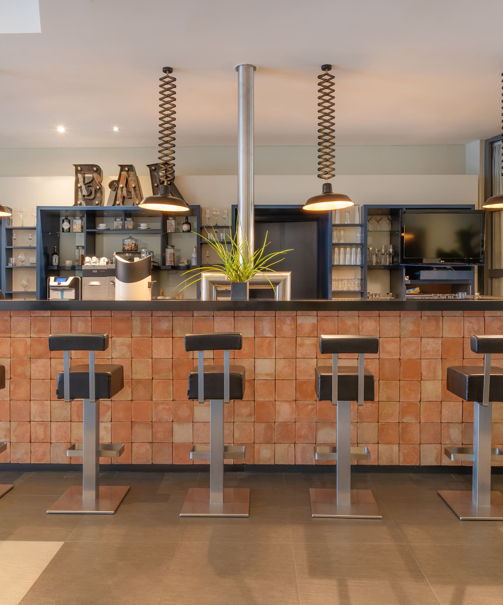 a bar with stools and lights