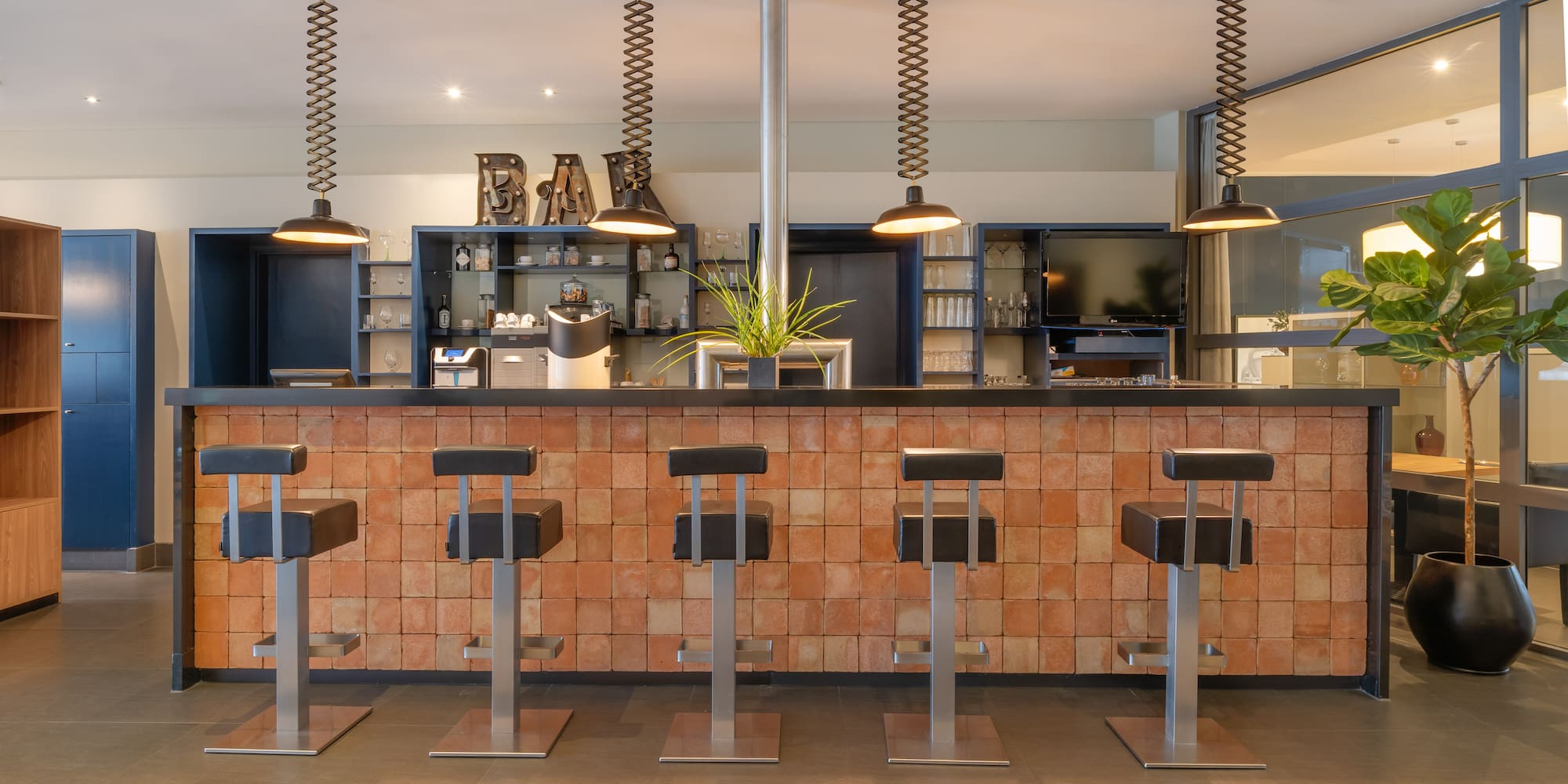 a bar with stools and lights