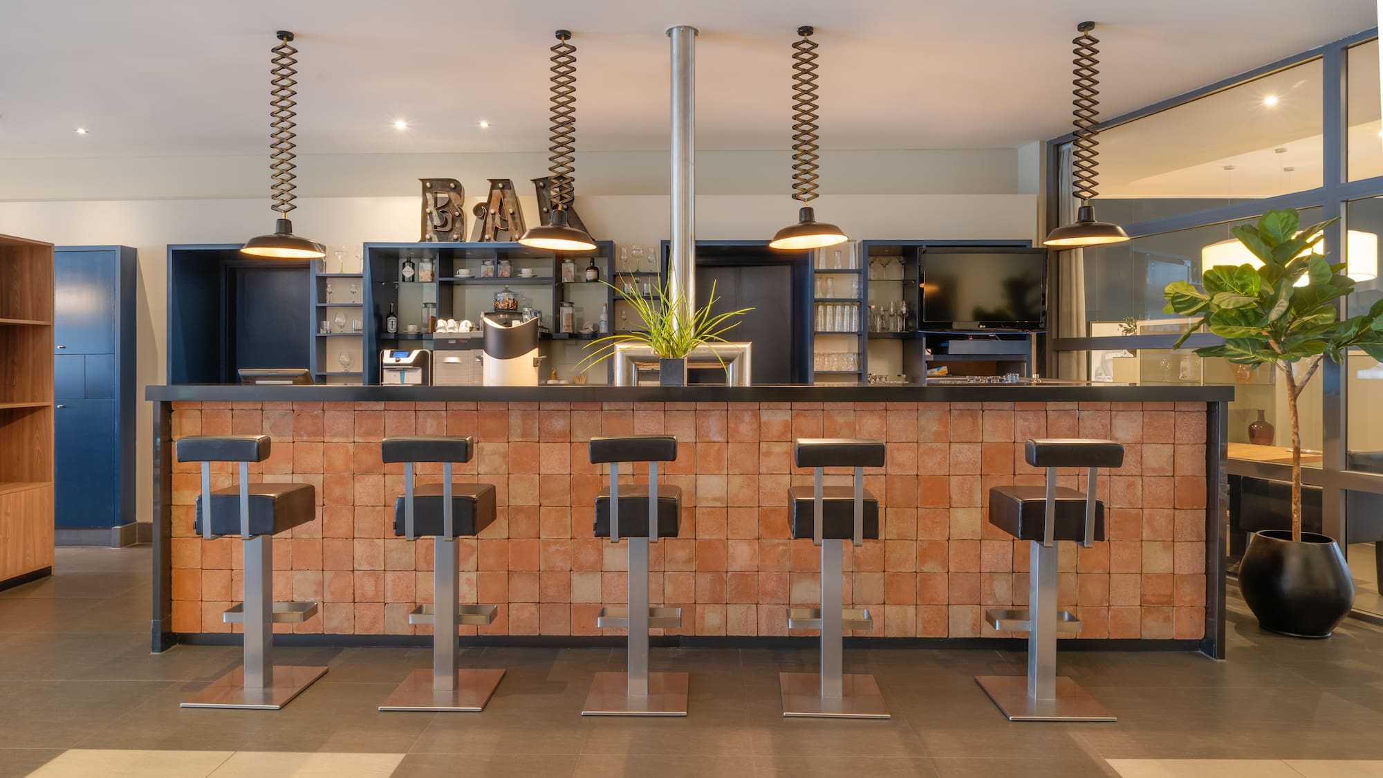 a bar with stools and lights