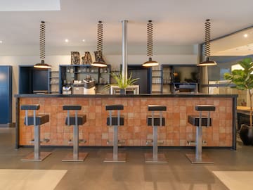 a bar with stools and lights