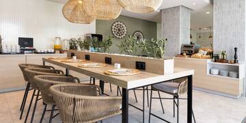 a dining table with chairs and a table with plates and a plant