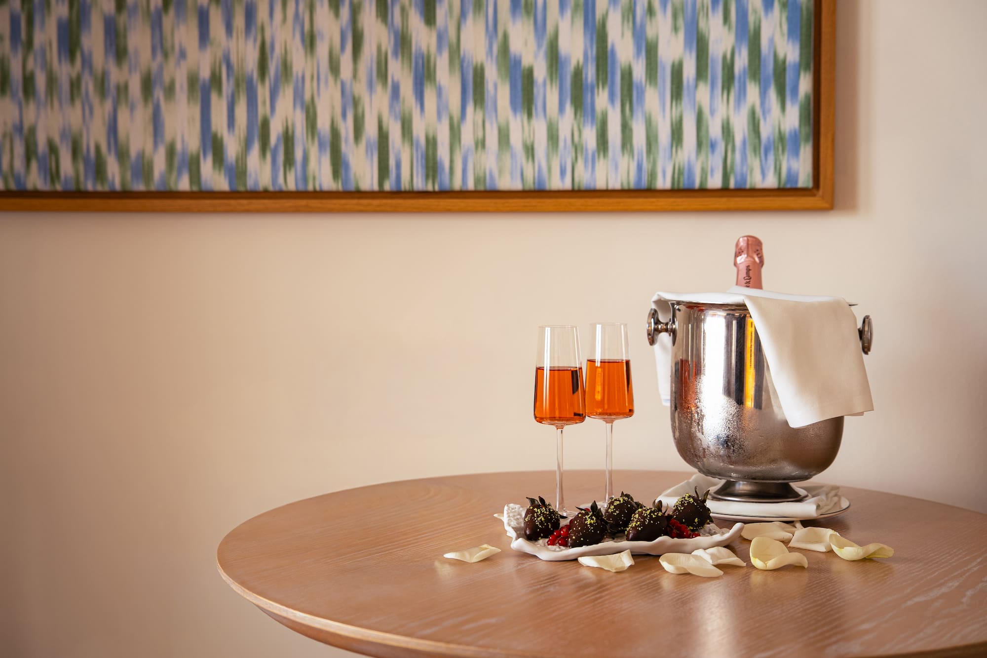 a champagne bucket and two glasses of wine on a table