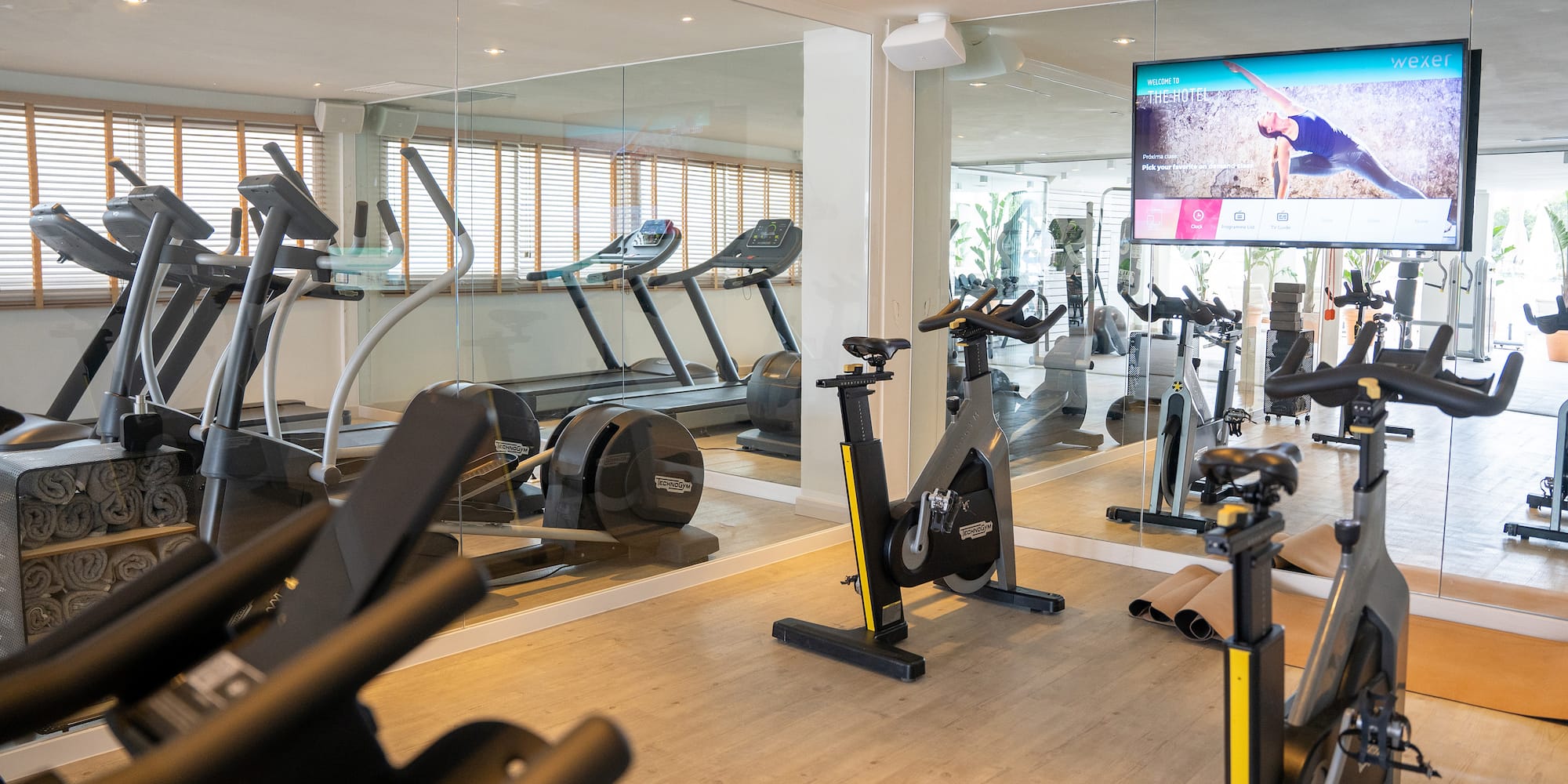 a room with exercise bikes and a mirror