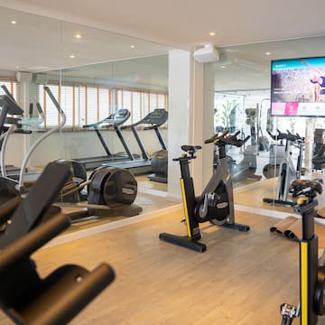a room with exercise bikes and a mirror