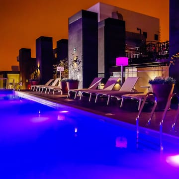a pool with chairs and purple lights