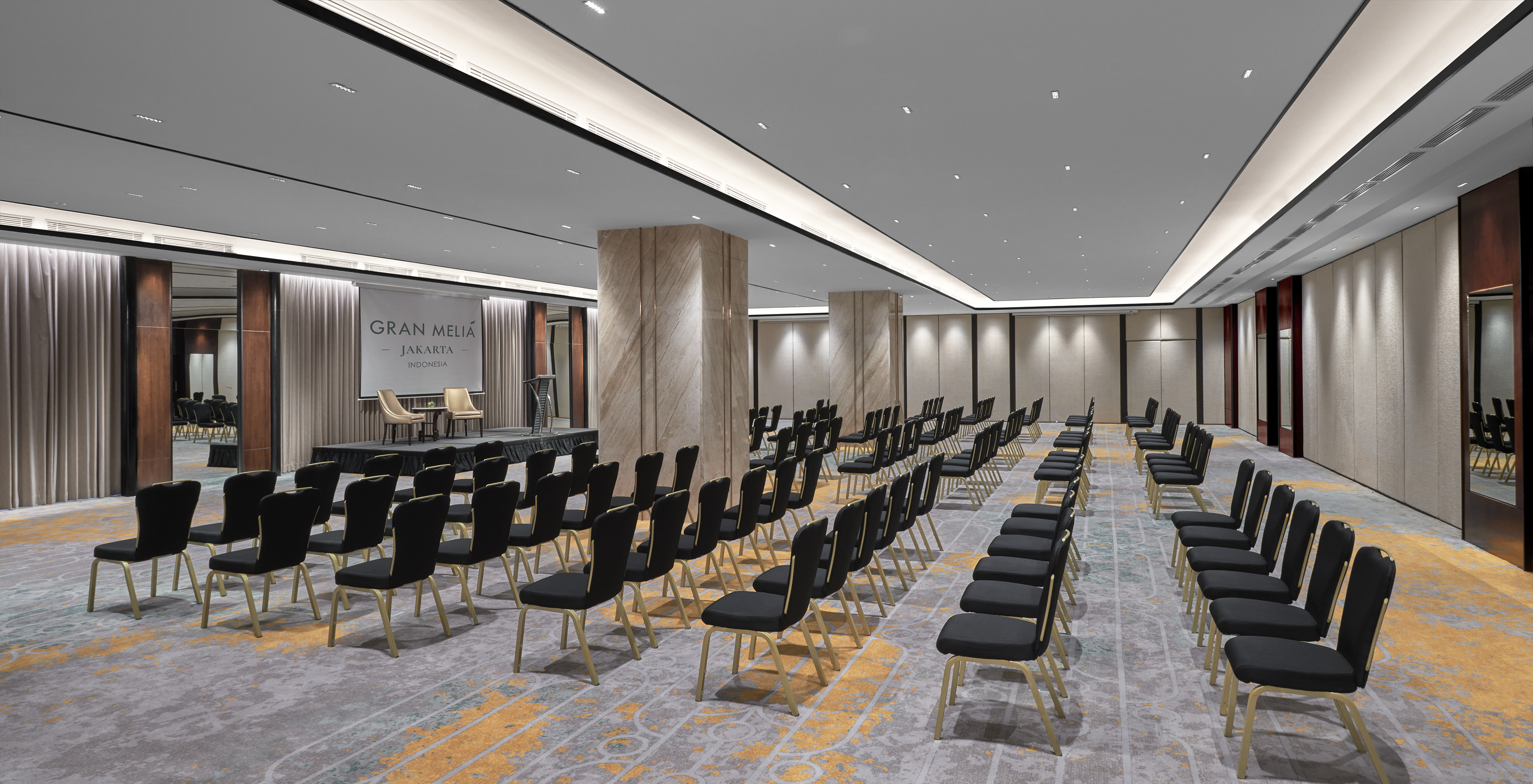 Modern Gran Melia Jakarta event space with stage, podium, and theater seating.