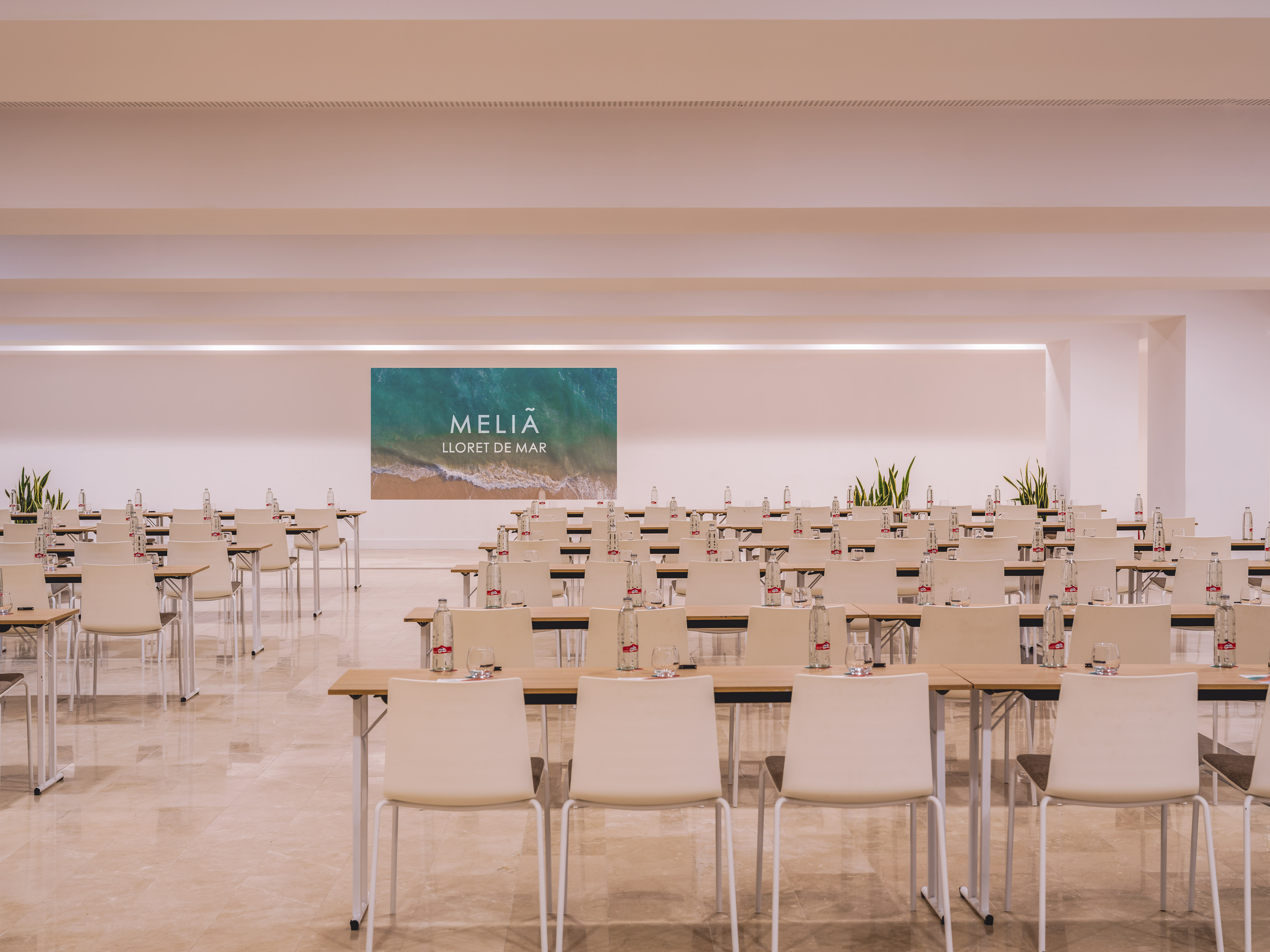 Meliã Lloret de Mar conference room with rows of tables, chairs, and screen.