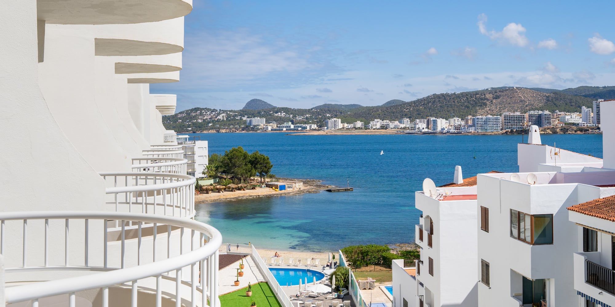 a view of a beach and buildings from a balcony.