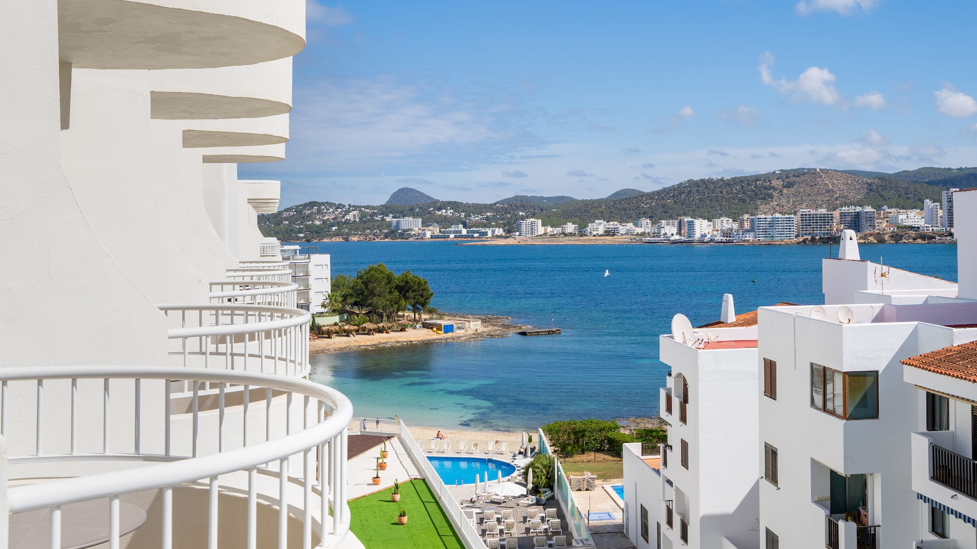 a view of a beach and buildings from a balcony.
