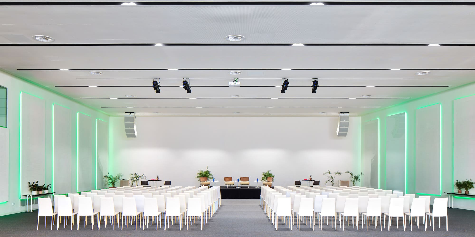 a room with white chairs and a stage