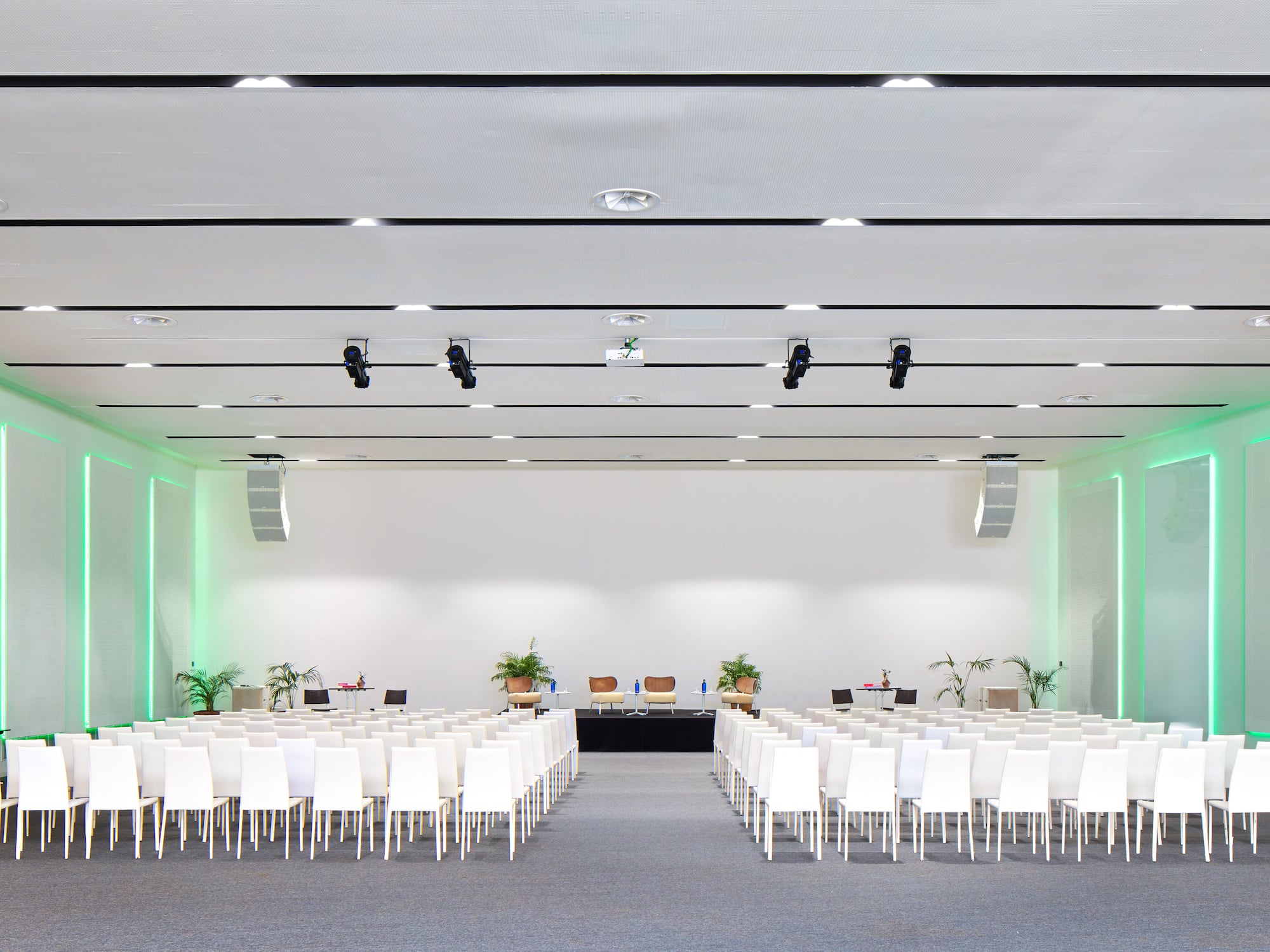 a room with white chairs and a stage