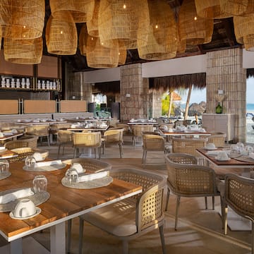 a restaurant with wicker chairs and tables