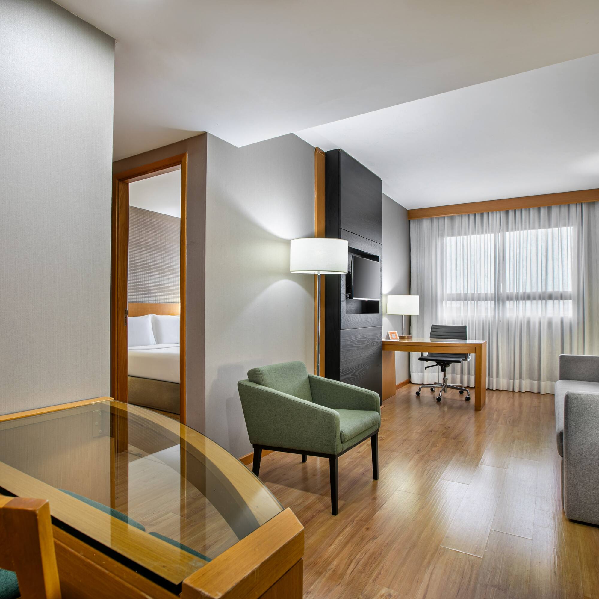 Contemporary hotel suite with separate living and sleeping areas.