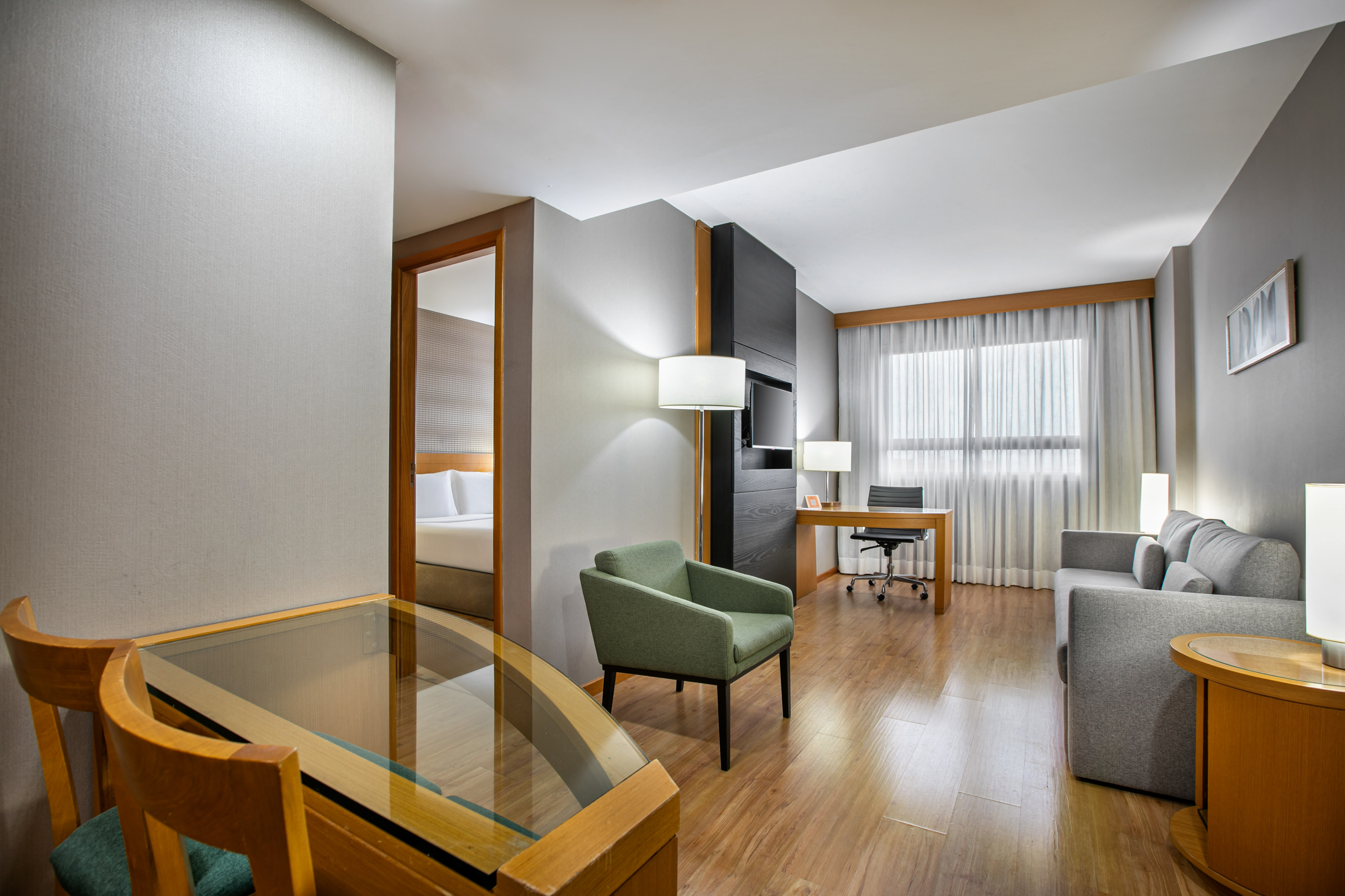 Contemporary hotel suite with separate living and sleeping areas.