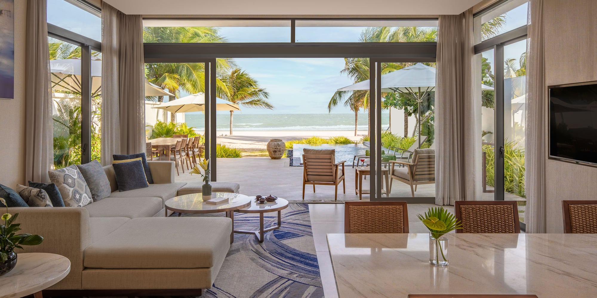 a living room with a large glass door and a large couch